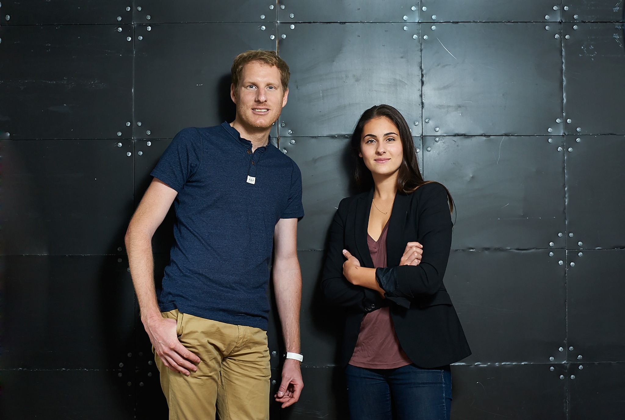 Studio-Team vor dunkler Metallwand